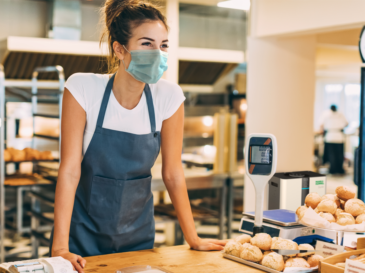 masked women working at bakery with SQ500 in background