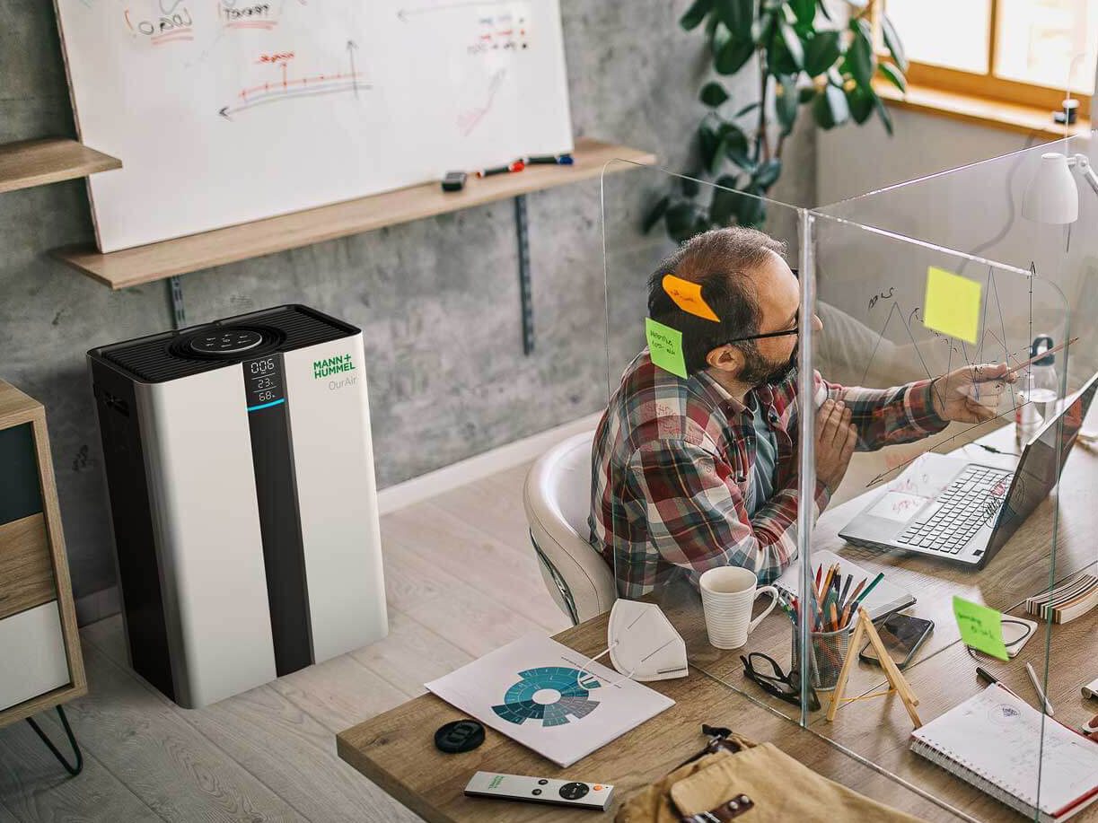 colleagues collaborating in open office setting with SQ500 air purifier in background